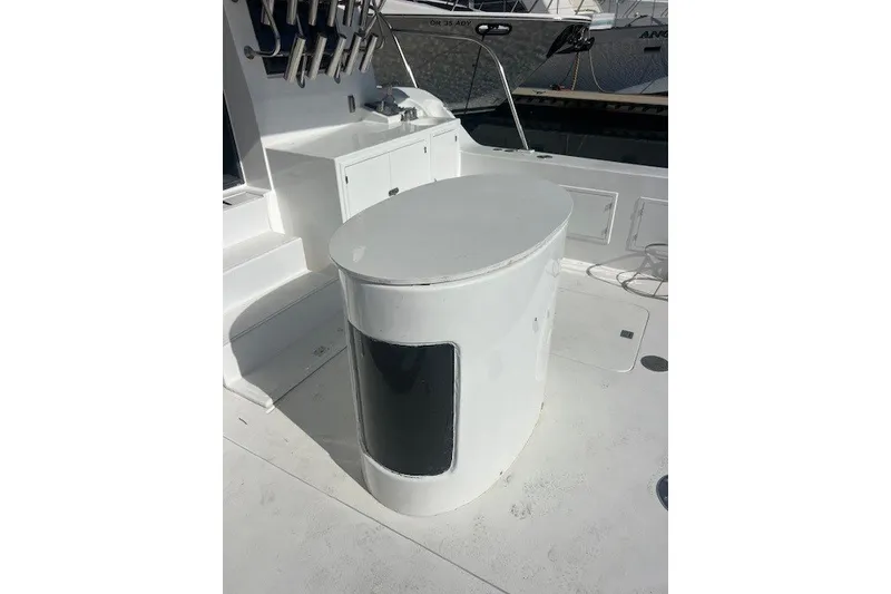 Slide: The Image of White deck area of a 1994 Mikelson 64 yacht with storage and seating. - 70