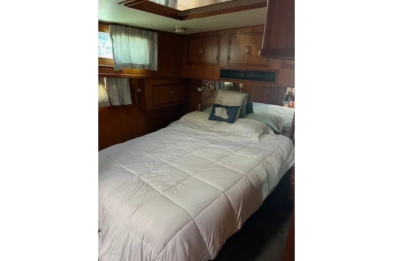 Slide: The Image of Cozy bedroom in a 1994 Mikelson 64 yacht with wood paneling and white bedding. - 52