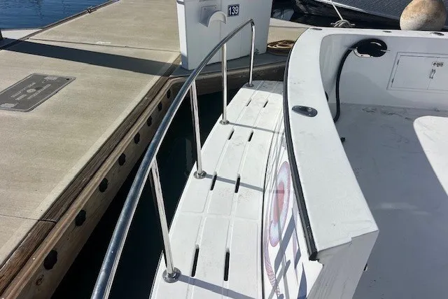 Slide: The Image of Docked 1994 Mikelson 64 yacht with stainless steel railings and white deck. - 72