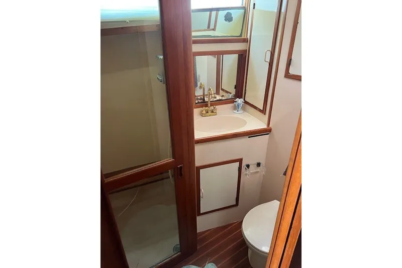 Slide: The Image of Bathroom interior of 1994 Mikelson 64 yacht with wooden accents and gold fixtures. - 54