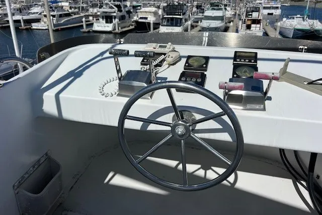 Slide: The Image of Helm of 1994 Mikelson 64 yacht with steering wheel and controls, docked at marina. - 65