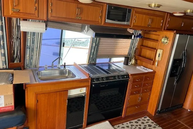 Slide: The Image of 1994 Mikelson 64 yacht kitchen with wooden cabinetry, stainless steel appliances, and large windows. - 46