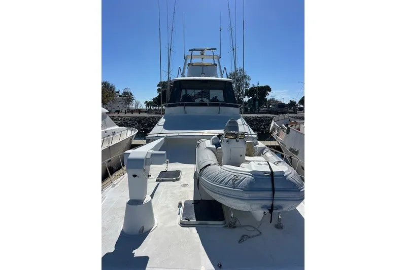 Slide: The Image of 1994 Mikelson 64 yacht with inflatable boat on deck, docked at marina. - 37