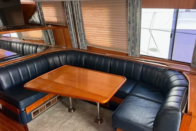 Slide: The Image of Luxurious interior of a 1994 Mikelson 64 yacht with leather seating and wooden table. - 47