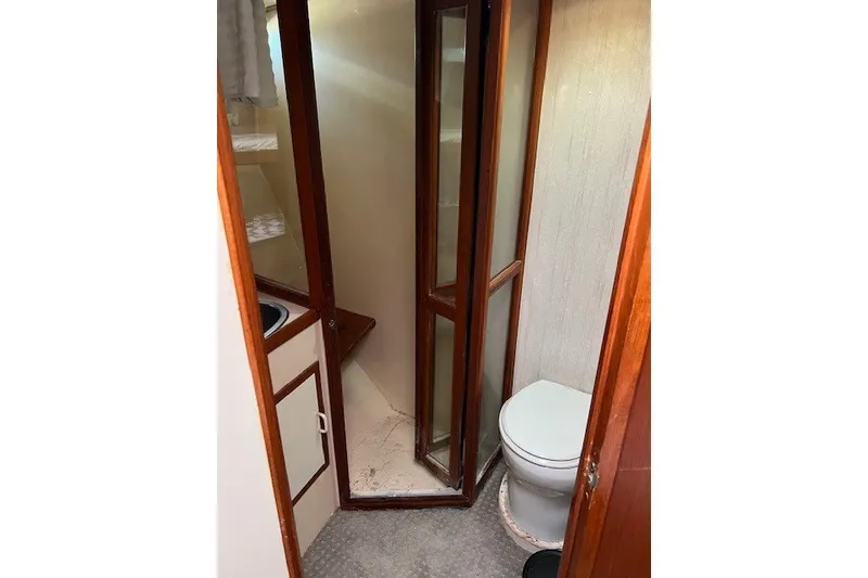 Slide: The Image of Bathroom interior of a 1994 Mikelson 64 yacht, featuring a shower and toilet. - 55