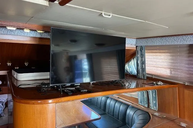 Slide: The Image of Interior of a 1994 Mikelson 64 yacht with a large TV and seating area. - 51