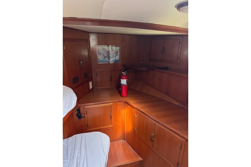 Slide: The Image of Interior of 1994 Mikelson 64 yacht with wooden cabinetry and fire extinguisher. - 56