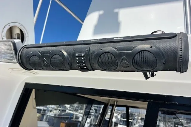 Slide: The Image of Outdoor speaker system mounted on a 1994 Mikelson 64 yacht, with marina background. - 63