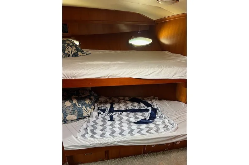 Slide: The Image of Bunk beds in a 1994 Mikelson 64 yacht cabin with nautical-themed decor. - 57