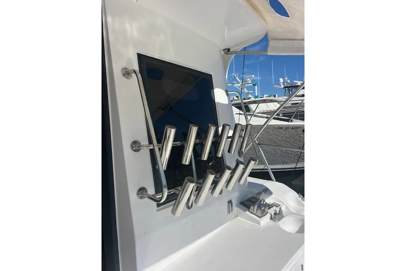 Slide: The Image of Rod holders on a 1994 Mikelson 64 yacht, docked with other boats in the background. - 69