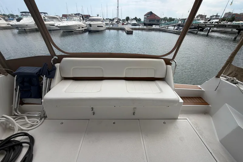 Slide: The Image of 1999 Carver 380 Santego yacht interior with white seating, docked at marina. - 14