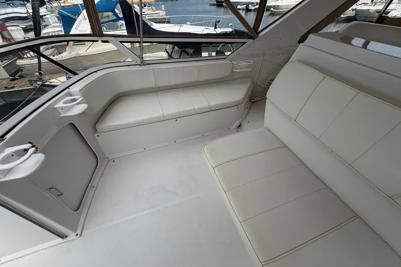 Slide: The Image of 1999 Carver 380 Santego yacht interior with white seating and marina view. - 25
