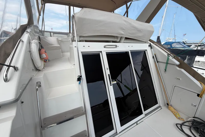 Slide: The Image of 1999 Carver 380 Santego yacht with sliding glass doors and upper deck access. - 15
