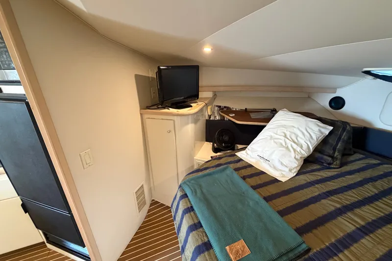 Slide: The Image of Cozy cabin interior of 1999 Carver 380 Santego with bed, TV, and striped bedding. - 45