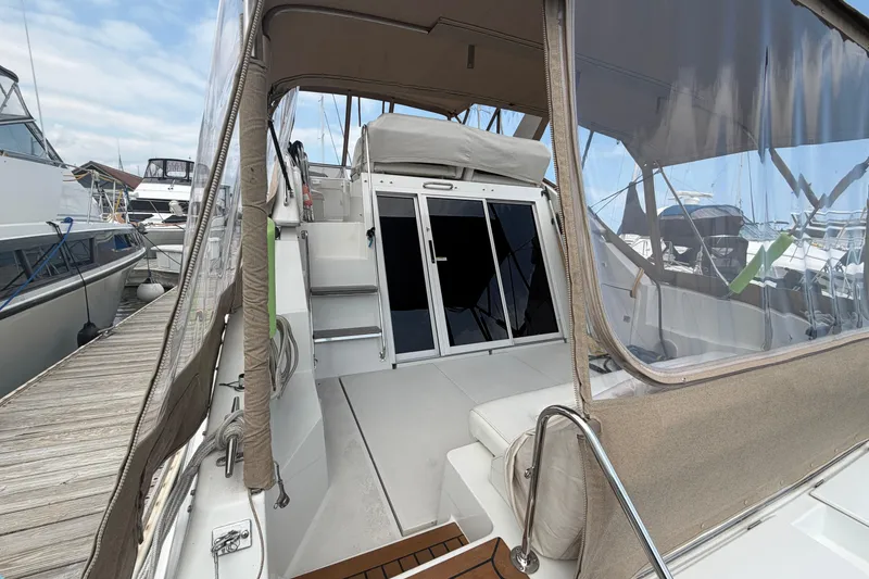 Slide: The Image of 1999 Carver 380 Santego yacht interior with clear canopy and docked boats in background. - 12