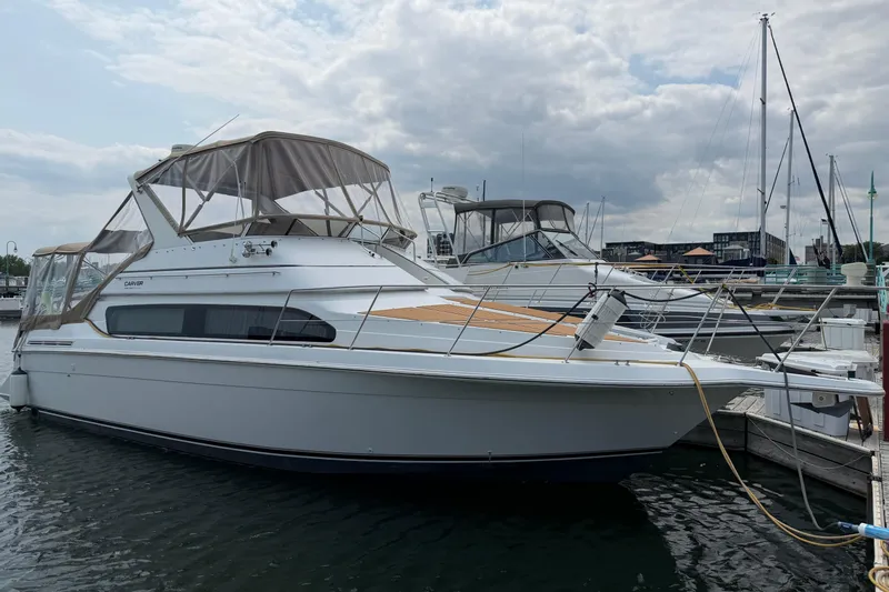 The Image of 1999 Carver 380 Santego yacht docked at marina under cloudy sky. - 1