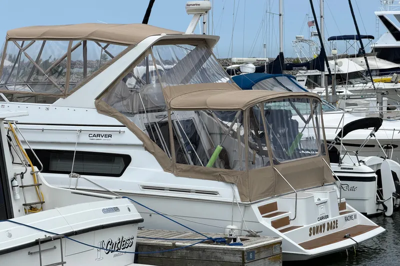 Slide: The Image of 1999 Carver 380 Santego yacht docked at marina, featuring tan canopy and sleek design. - 54