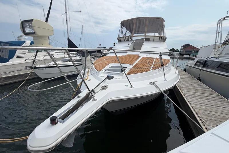 Slide: The Image of 1999 Carver 380 Santego yacht docked at marina, featuring spacious deck and sleek design. - 5