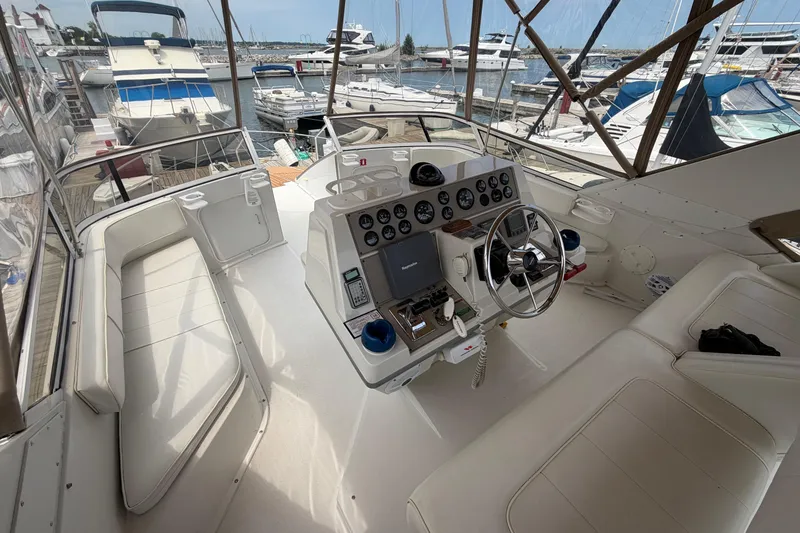 Slide: The Image of 1999 Carver 380 Santego yacht cockpit with steering wheel, gauges, and marina view. - 17