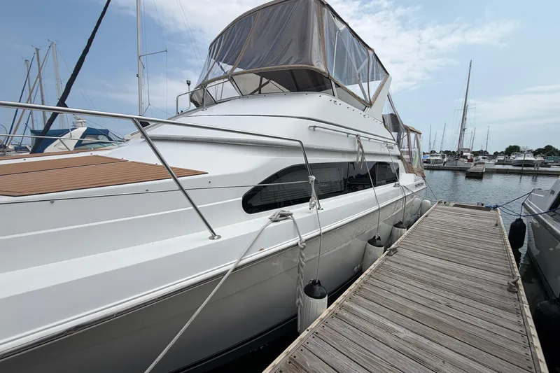 Slide: The Image of 1999 Carver 380 Santego yacht docked at marina, featuring sleek design and spacious deck. - 7