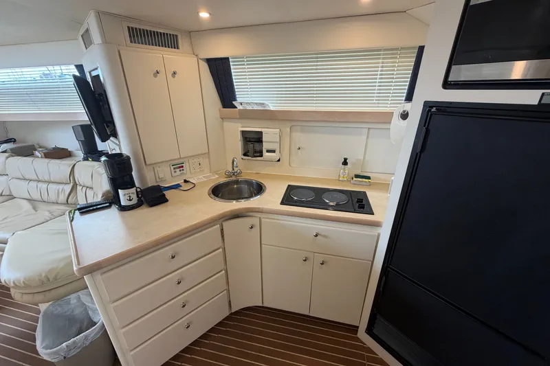 Slide: The Image of Interior of 1999 Carver 380 Santego yacht kitchen with sink, stove, and appliances. - 38