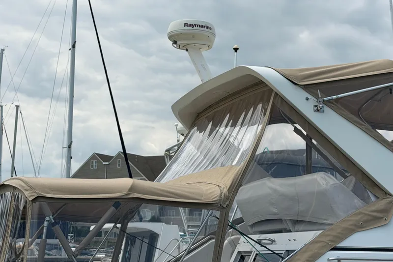 Slide: The Image of 1999 Carver 380 Santego yacht with beige canopy docked at marina. - 3