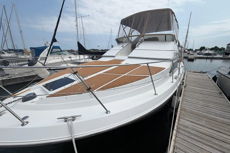 Slide: The Image of 1999 Carver 380 Santego yacht docked at marina, featuring sleek design and spacious deck. - 6