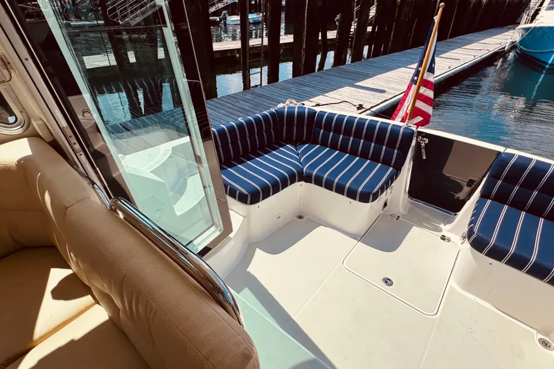 Slide: The Image of 2018 Back Cove 37 boat with striped seating and American flag at dock. - 59