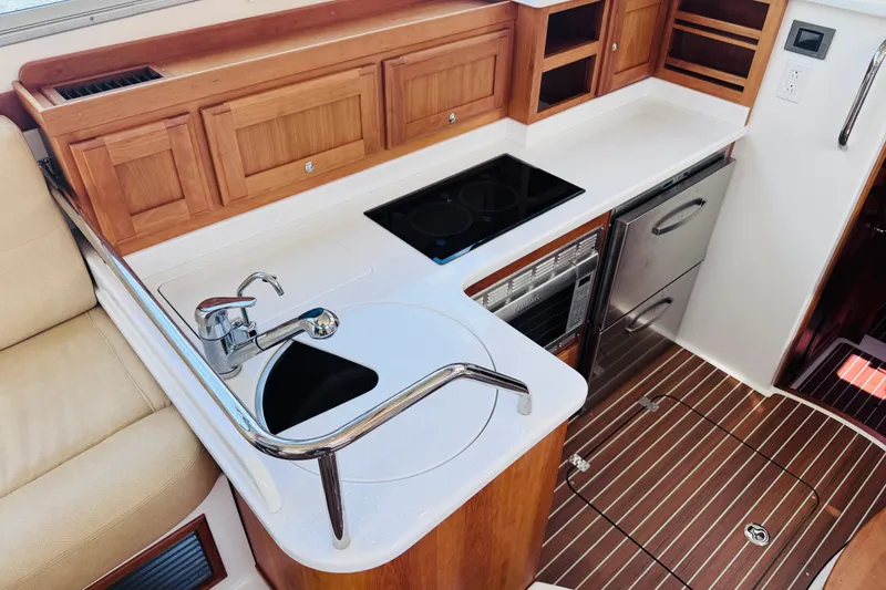 Slide: The Image of 2018 Back Cove 37 yacht kitchen with sink, stove, and wooden cabinetry. - 20