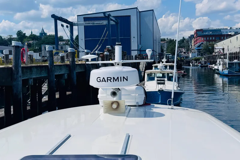 Slide: The Image of 2018 Back Cove 37 docked, featuring Garmin equipment, with waterfront buildings in the background. - 51