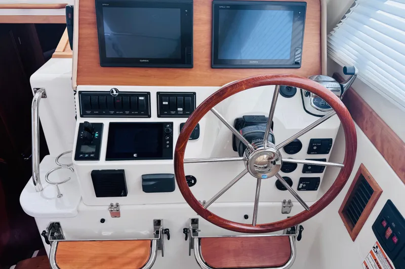 Slide: The Image of Helm station of 2018 Back Cove 37 with dual Garmin displays and wooden steering wheel. - 30