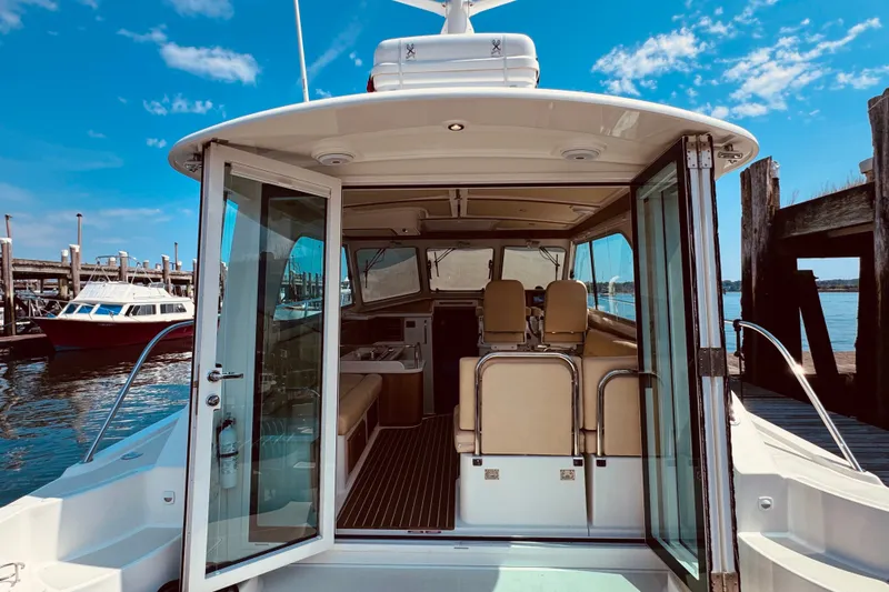 Slide: The Image of 2018 Back Cove 37 yacht interior view with open doors at a marina. - 61