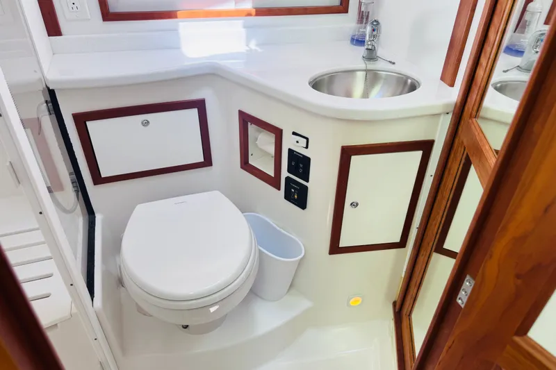 Slide: The Image of 2018 Back Cove 37 yacht bathroom with toilet, sink, and wooden accents. - 18