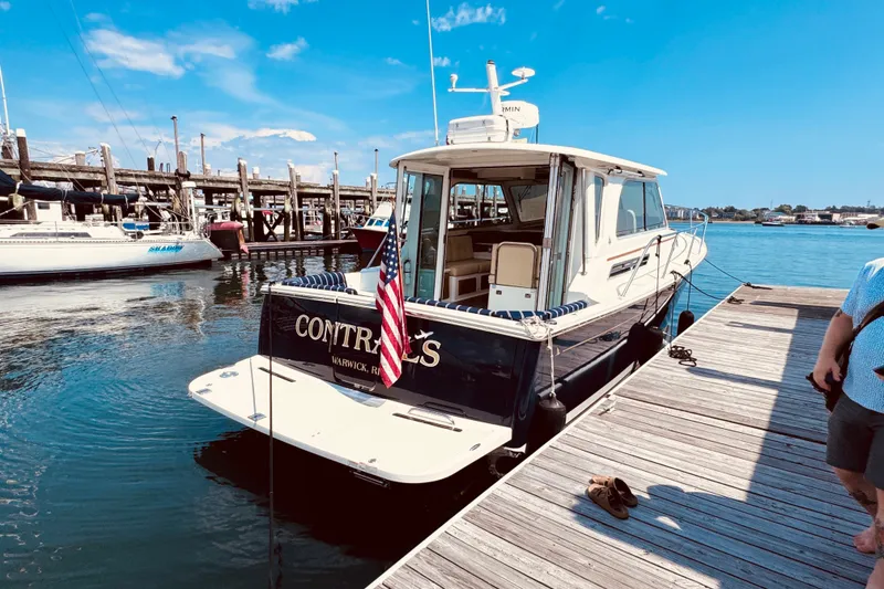 Slide: The Image of 2018 Back Cove 37 docked at marina, clear sky, American flag displayed. - 1