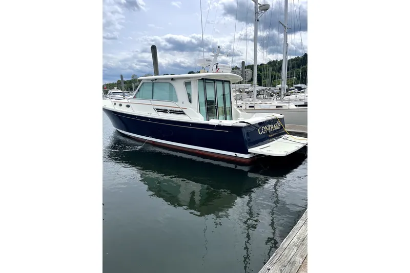The Image of 2018 Back Cove 37 yacht docked at marina, reflecting on calm water. - 0