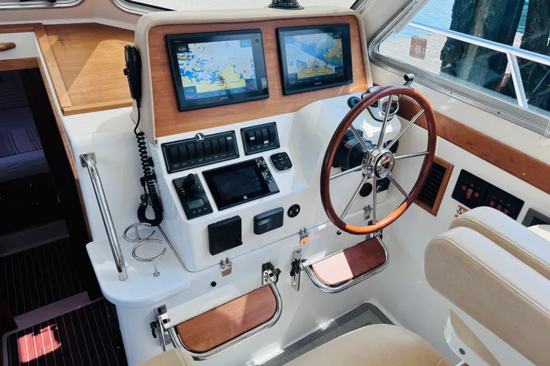 Slide: The Image of Helm of 2018 Back Cove 37 boat with dual navigation screens and wooden steering wheel. - 29