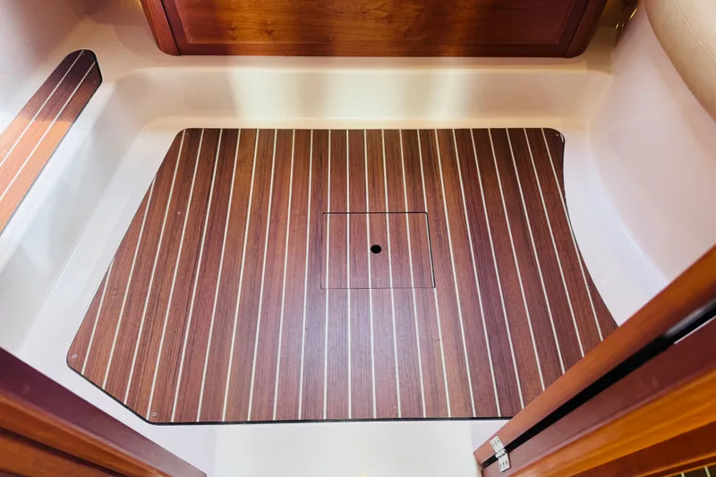 Slide: The Image of 2018 Back Cove 37 boat interior with wood-patterned flooring and storage hatch. - 12