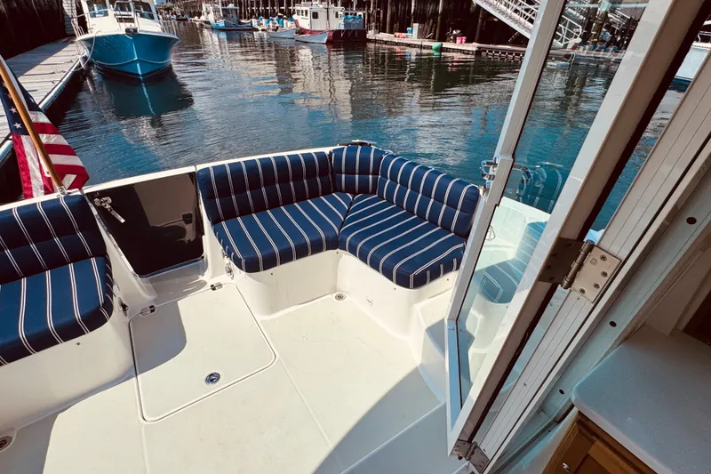 Slide: The Image of 2018 Back Cove 37 boat with striped seating, docked in a marina. - 58
