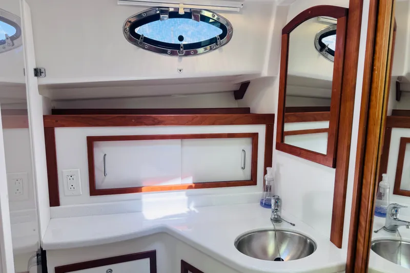 Slide: The Image of 2018 Back Cove 37 yacht bathroom with sink, mirror, and wooden accents. - 17