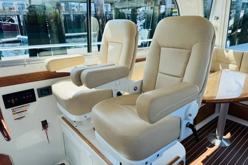 Slide: The Image of Interior of 2018 Back Cove 37 yacht with beige captain chairs and wooden table. - 32
