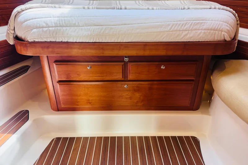 Slide: The Image of 2018 Back Cove 37 cabin interior with wooden drawers and bed. - 11