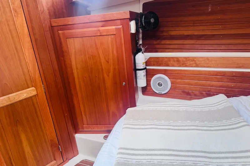 Slide: The Image of Cozy cabin interior of 2018 Back Cove 37 with wooden paneling and striped bedding. - 7