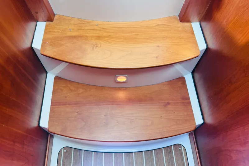 Slide: The Image of Wooden steps inside a 2018 Back Cove 37 boat, featuring warm tones and sleek design. - 45