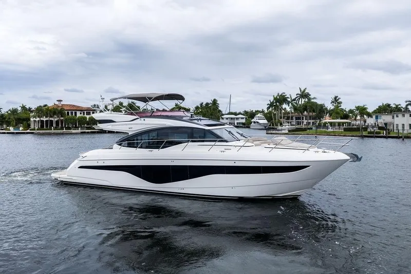Slide: The Image of Luxury 2020 Princess S62 yacht cruising on a scenic waterfront with palm trees. - 5