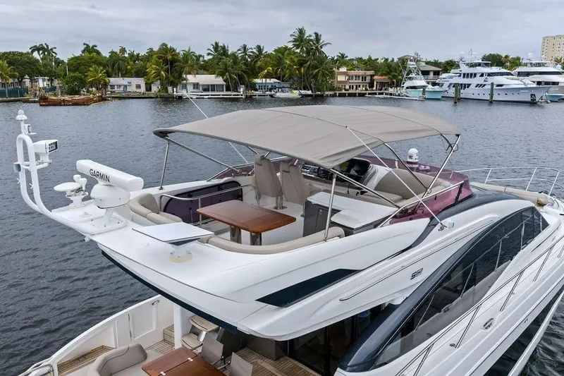Slide: The Image of Luxury 2020 Princess S62 yacht with canopy, docked near waterfront homes and palm trees. - 7