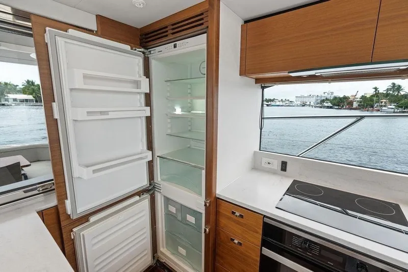 Slide: The Image of Modern yacht kitchen with open fridge, stove, and waterfront view. Princess S62, 2020 model. - 39