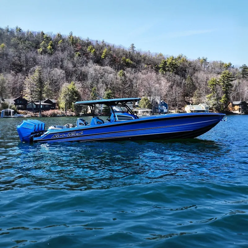 The Image of 2026 Nor-Tech 390 Sport boat on a scenic lake with wooded shoreline. - 0