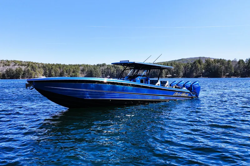 Slide: The Image of 2026 Nor-Tech 390 Sport boat on a serene lake with forested shoreline. - 4