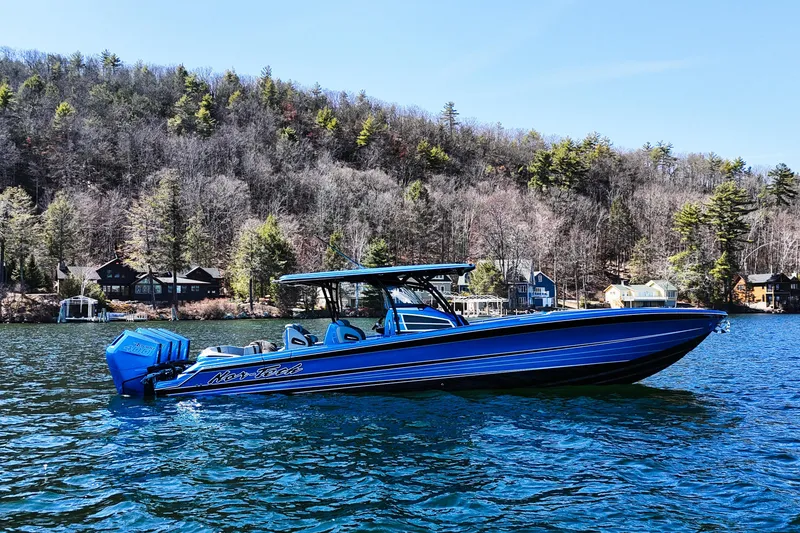 Slide: The Image of 2026 Nor-Tech 390 Sport boat on a scenic lake with wooded shoreline. - 2