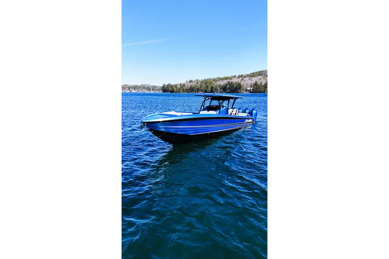 Slide: The Image of 2026 Nor-Tech 390 Sport boat on a serene lake under clear blue skies. - 6